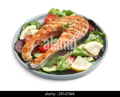 Leckeres Lachssteak mit Zitrone und Gemüse auf weißem Hintergrund Stockfoto