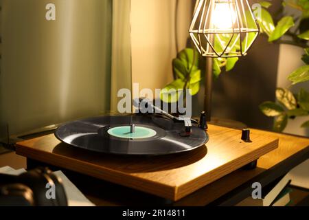 Eleganter Plattenspieler mit Schallplatte auf dem Tisch im Innenbereich Stockfoto