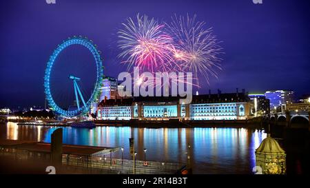 Feuerwerk am Londoner Himmel neben der Themse und dem berühmten Riesenrad. Festlichkeiten im Vereinigten Königreich Stockfoto