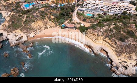 Ein unvergleichliches Luftfoto der wunderschönen Stadt Albufeira in Portugal, das den Strand Praia dos Aveiros zeigt und Menschen, die sich im Urlaub entspannen Stockfoto