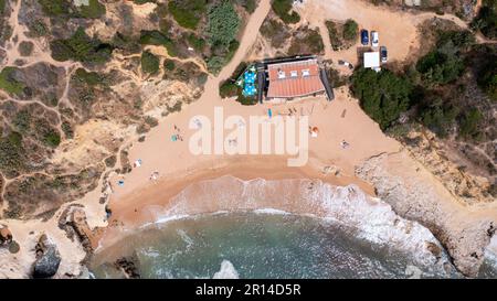 Ein unvergleichliches Luftfoto der wunderschönen Stadt Albufeira in Portugal, das den Strand Praia dos Aveiros zeigt und Menschen, die sich im Urlaub entspannen Stockfoto