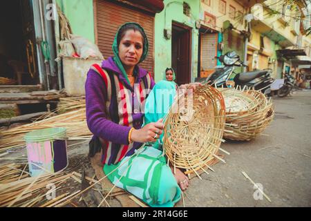 Jaisalmer, Indien - 19. Januar 2020 : Weicher Fokus auf Indianerfrau webt Bambuskorb . Aus Bambusbasketry hergestellte Vase. Stockfoto