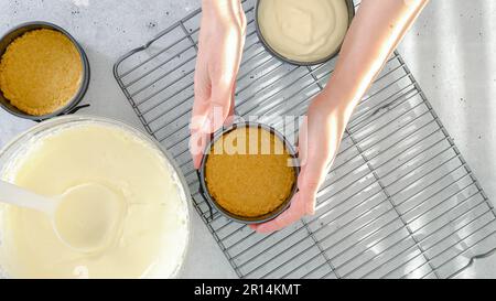 Kleines Käsekuchen-Rezept. Käsekuchen-Teig in eine vorbereitete Backform gießen, Nahzubereitung, flach legen Stockfoto