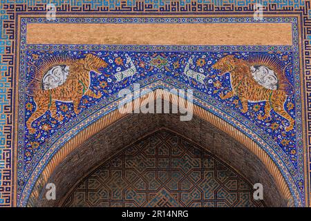 Details des oberen Portals der sher-Dor-Madrasa zeigen Mosaiken von Tigern oder Löwen mit personifiziertem Sonnenaufgang auf dem registan Square samarkand Stockfoto