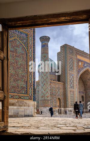 Gerahmter Blick durch die Tür des registan Square samarkand in Richtung des blauen Rippturm und Portal von sher Dor Mahrazah Stockfoto