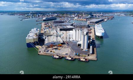 Ro-Ro-Schiffe, die neue Autos im Hafen von Southampton an der Ärmelkanalküste in Südengland, Vereinigtes Königreich, entladen - großer Polder, der zur Internierung verwendet wird Stockfoto