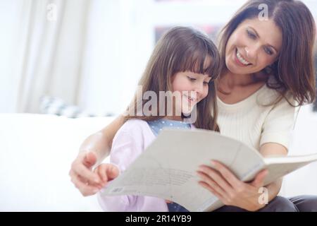 Sich im Märchen zu verirren. Mutter und Tochter lesen zusammen ein Buch. Stockfoto