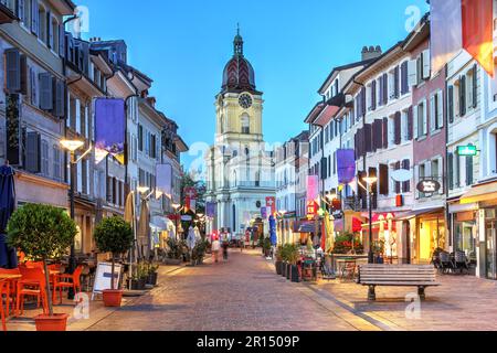 Nachtszene entlang der Grand Rue in Morges, Schweiz, mit Temple de Morges im Hintergrund. Stockfoto