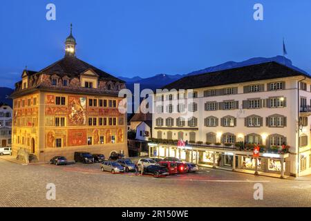 Das Rathaus der Stadt Schwyz in der Zentralschweiz mit unverwechselbaren Wandmalereien am Hauptplatz während eines Sommerabends. Stockfoto