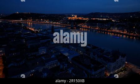 Blick aus der Vogelperspektive auf Burgberg, Budaer Burg, Gellert-Hügel und die Zitadelle mit Donau, Brücken beleuchtet nach Sonnenuntergang in Budapest Stockfoto