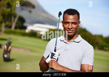 Golf ist mein Leben. Porträt eines gutaussehenden jungen Mannes, der einen Tag auf dem Golfplatz genießt. Stockfoto