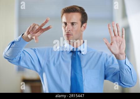 Expandieren Sie Ihr Geschäft mit Technologie. Ein attraktiver junger Geschäftsmann, der eine digitale Schnittstelle verwendet. Stockfoto