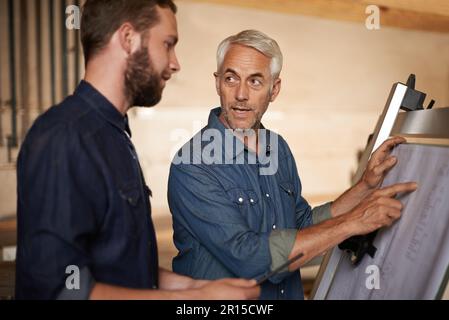 Von den Besten lernen. Ein Vater und Sohn, die an einem Bauprojekt arbeiten. Stockfoto