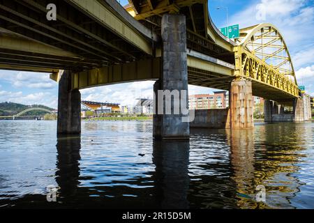Von unten verläuft die Fort Duquesne Bridge über den Allegheny River in Pittsburgh, Pennsylvania. Das Acrisure Football Stadium und die West End Bridge sind ebenfalls vorhanden Stockfoto