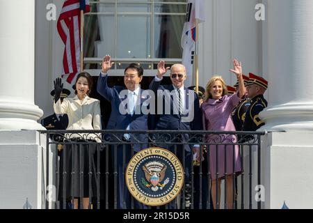 Präsident Joe Biden, First Lady Jill Biden, Präsident der Republik Korea Yoon Suk Yeol und First Lady Kim Keon Hee winken am Mittwoch, den 26. April 2023, nach der offiziellen Ankunftszeremonie des Bundesstaates auf dem Südrasen. (Offizielles Foto des Weißen Hauses von Cameron Smith) Stockfoto