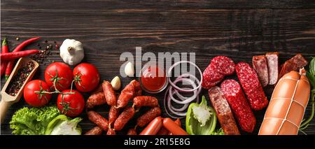 Verschiedene Arten von Würstchen mit Sauce, Gewürze und Gemüse auf Holz- Hintergrund Stockfoto