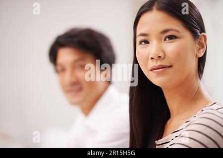 Ich bin sicher, dass die Muschel es nach oben schafft. Porträt einer attraktiven asiatischen Geschäftsfrau, die neben einem männlichen Kollegen sitzt. Stockfoto