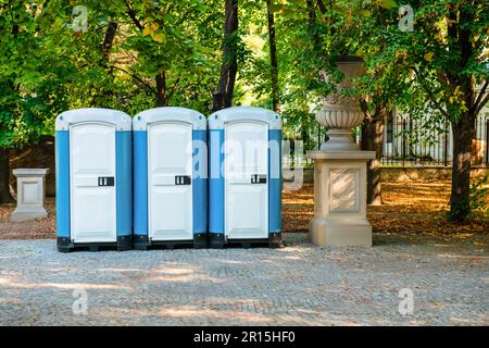 Öffentliche Toilettenkabinen auf der Straße in der Nähe von Bäumen Stockfoto