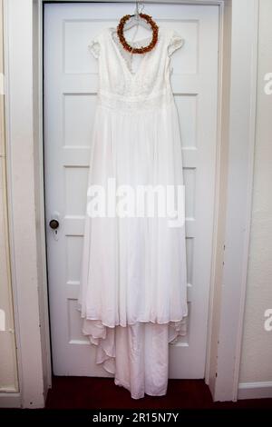 boho Weißes Hochzeitskleid Korsett aus der Nähe mit orangefarbenem Kopfkranz, Blumenkrone, geblümtem Kopfstück, das in der Tür liegt Stockfoto