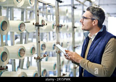 Für Kraft gemacht. Ein Mann, der ein Produkt in einer Kunststofffabrik inspiziert. Stockfoto