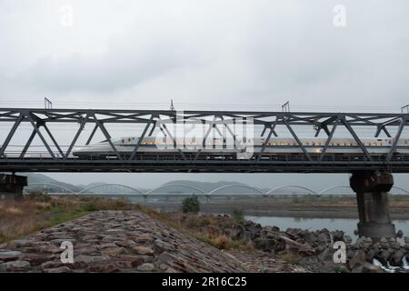 SHIZUOKA, JAPAN - 6. APRIL 2023: Tokaido Shinkansen überquert die Fuji View Shinkansen Eisenbahnbrücke am Abend Stockfoto