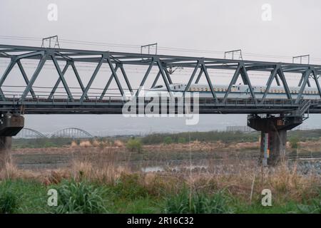 SHIZUOKA, JAPAN - 6. APRIL 2023: Tokaido Shinkansen überquert die Fuji View Shinkansen Eisenbahnbrücke am Abend Stockfoto