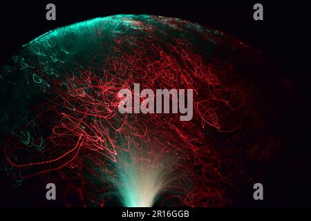 Moving light fibers creating beautiful light traces and patterns of green and red with a black background. Stockfoto