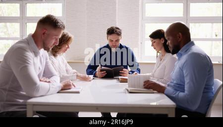 Gruppe von Jungen multiethnischen Menschen Lesen der Bibel über Holz- Schreibtisch Stockfoto
