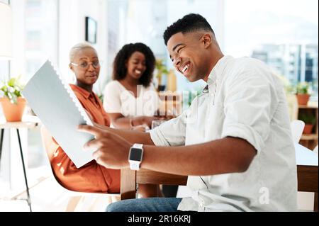 Dieser Vorschlag wird uns zum Erfolg führen. Ein junger Geschäftsmann, der mit seinen Kollegen in einem Büro Papierkram durchsucht. Stockfoto