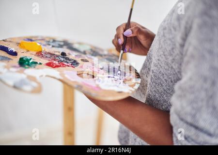 Wir alle brauchen etwas Farbe in unserem Leben. Eine unbekannte Frau mit einer Malerpalette. Stockfoto