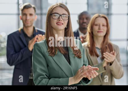 Porträt einer jungen, seriösen Geschäftsfrau mit Kollegen Stockfoto