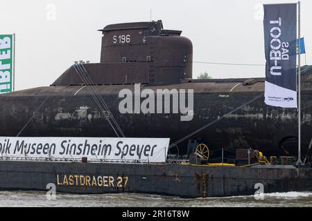 Bimmen, Deutschland. 12. Mai 2023. Das U-Boot auf einem schwimmenden Ponton passiert das Dorf Bimmen am Rhein. U 17, ein U-Boot der Klasse 206A, soll im Speyer Museum of Technology ankommen. Das Boot, das mehr als 35 Jahre lang der deutschen Marine diente, verließ Kiel am 28. April auf einem schwimmenden Ponton über den Kieler Kanal, die Nordsee und den Rhein in Richtung Speyer. Kredit: Christoph Reichwein/dpa/Alamy Live News Stockfoto