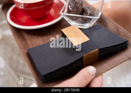 Die Frau im Bademantel setzt sich mit einer Tasse Kaffee und Obst hin Stockfoto