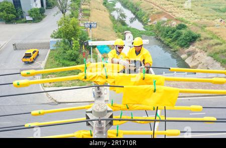 CHUZHOU, CHINA - 12. MAI 2023 - Arbeiter ersetzen den intelligenten Schalter am 25-Pol der 10 kV Yuhong 132-Linie, Chuzhou City, Anhui Province, China, Mai Stockfoto