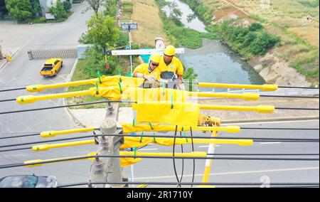 CHUZHOU, CHINA - 12. MAI 2023 - Arbeiter ersetzen den intelligenten Schalter am 25-Pol der 10 kV Yuhong 132-Linie, Chuzhou City, Anhui Province, China, Mai Stockfoto