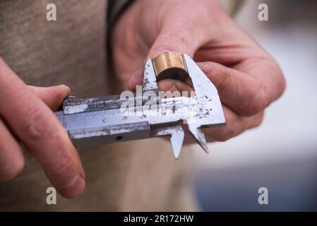 Metallstab zirkuliert automatisch mechanisch misst das gewünschte Teil, das der Arbeiter misst, bis zum Innendurchmesser des Flansches mit einem Nonius von ca. Stockfoto