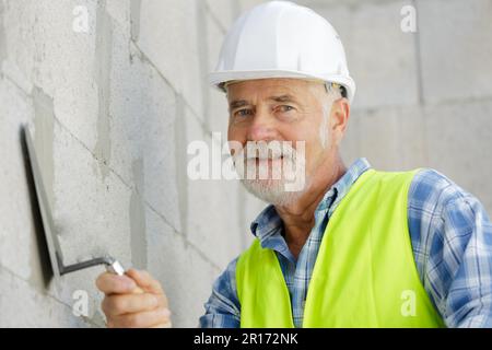 Leitender Angestellter, der an der Fassade arbeitet Stockfoto