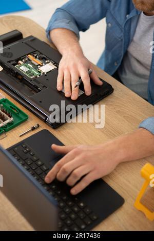 Nahaufnahme eines Mannes, der den Laptop untersucht Stockfoto