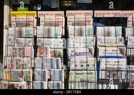 Titelseiten internationaler und britischer Zeitungen vor einem Zeitungsmagazin im Zentrum von London, England, Großbritannien Stockfoto