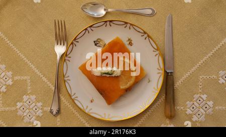 Elegante Tischeinrichtung mit einem leckeren Gericht garniert mit Zitronenscheibe und Creme Stockfoto