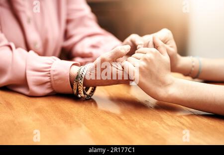 Du wirst nie allein sein. Eine Krankenschwester, die eine ältere Frau behaglich an den Händen hält. Stockfoto