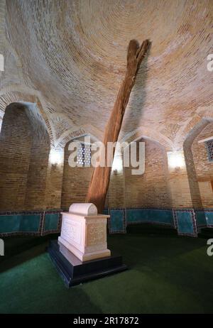 Weißes Marmorgrab mit großem Holzzweig. Im Sheikh Hovendi at-Tahur Mausoleum in Taschkent, Usbekistan. Stockfoto