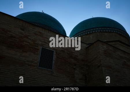 Doppelkuppeln mit grünen Fliesen und Schattendetails. Im Sheikh Hovendi at-Tahur Mausoleum in Taschkent, Usbekistan. Stockfoto