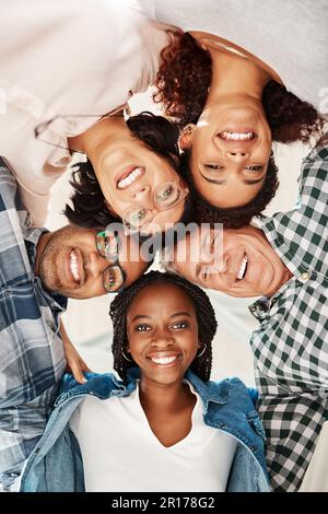 Das Gesicht der Teamsolidarität. Niedriges Porträt eines Teams von Kreativen, die in Einheit zusammengedrängt sind. Stockfoto