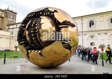 ROM, VATIKAN - 9. MÄRZ 2023: Dies ist eine moderne rotierende Skulpturenkugel innerhalb einer Kugel (Autor A. Pomodoro), die Besuchern im Innenhof ausgestellt wird Stockfoto