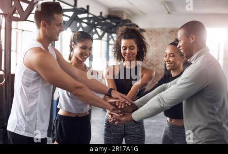 Gewinner umgeben sich mit Gewinnern. Eine Gruppe junger Menschen, die sich in einem Fitnessstudio solidarisch zusammentun. Stockfoto