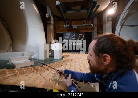 Dresden, Deutschland. 10. Mai 2023. Ein Mitarbeiter des Instituts für Luft- und Raumfahrttechnik der TU Dresden demonstriert im Rahmen eines vom Wirtschaftsministerium in Sachsen organisierten Thementags mit dem Titel „Luftfahrtindustrie“ eine Flussdarstellung mit einer Nebelsonde im Windkanal. Kredit: Robert Michael/dpa/Alamy Live News Stockfoto