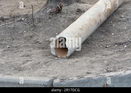 Alte Rohrleitungen aus Gusseisen auf dem Boden. Reparatur von Abwasser, Abwasser und Regenwasser. Sanitär, Abwassersystem für ein mehrstöckiges Gebäude. Bürgermeister Stockfoto