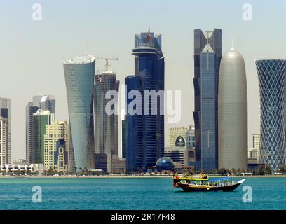 Katar, Doha: Neue Wolkenkratzer in der West Bay - Al Bidda Tower, Katar World Trade Centre, Palm Towers und Tornado Tower, mit vorbeifahrender Dhow. Nahaufnahme von Stockfoto