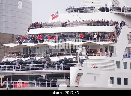 Passagiere an Bord des Silversea Silver Wind Kreuzfahrtschiffs, das durch die Tower Bridge in London geführt wird, wo es neben HMS Belfast festgemacht war. Foto: Freitag, 12. Mai 2023. Stockfoto